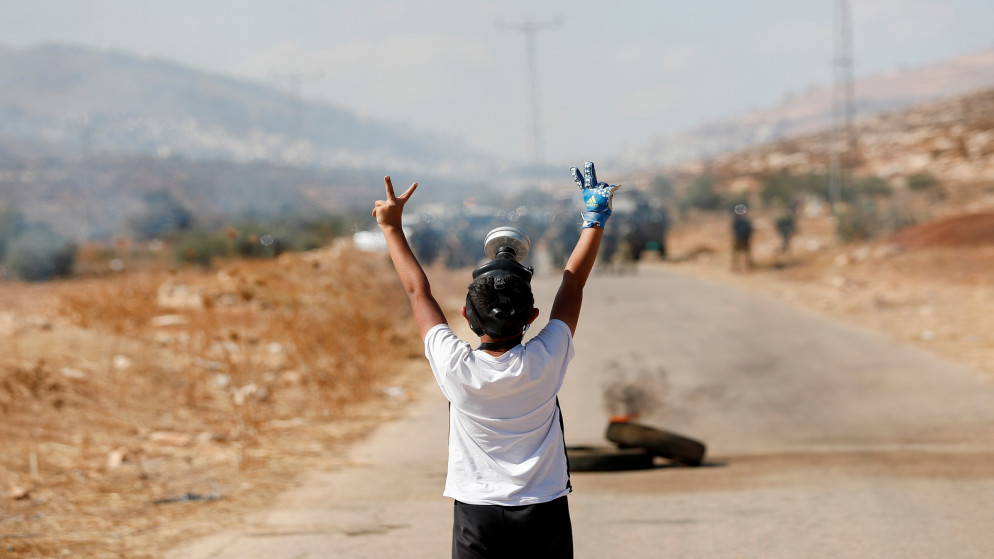 طفل فلسطيني يرفع علامة النصر أمام بيت دجن بالضفة الغربية المحتلة، 22 تشرين الأول/ أكتوبر 2021. (رويترز/ محمد توركمان)