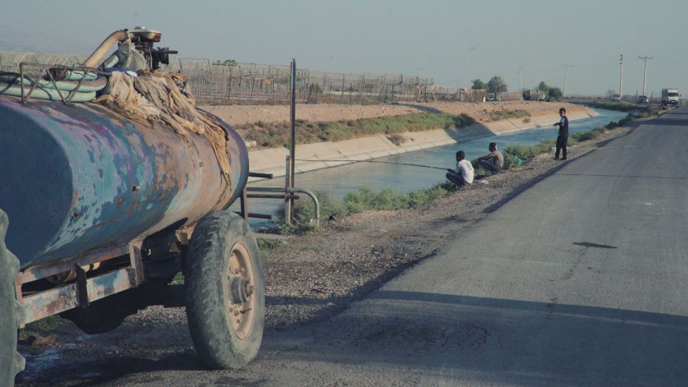 صورة شاحنة نقل مياه أمام قناة الملك عبدالله في الأغوار. (فادي اسكندراني/المملكة)