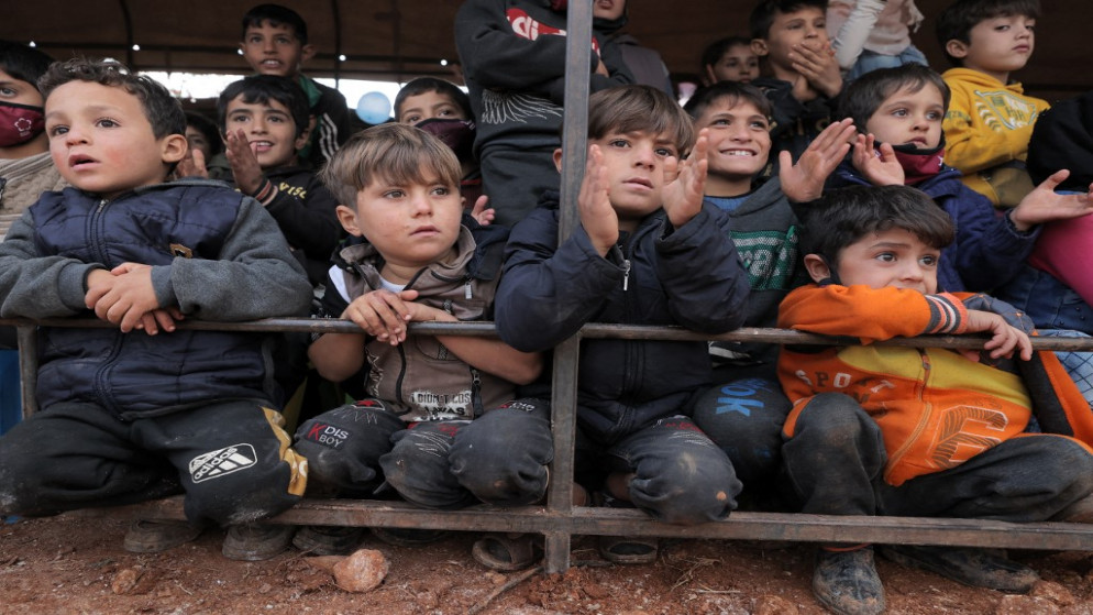 أطفال يحضرون حدثا في الهواء الطلق للاحتفال باليوم العالمي للطفل في مخيم للنازحين السوريين في شمال غرب إدلب السورية. 20/11/2021. (عمر الحاج قدور / أ ف ب)