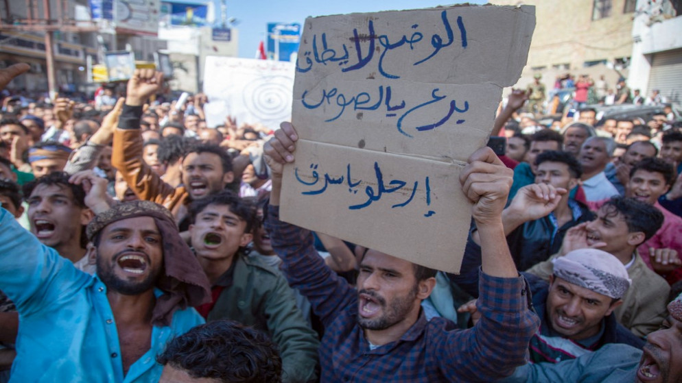 يمنيون يرددون شعارات خلال مظاهرة تطالب بإقالة الحكومة وتندد بالظروف الاقتصادية والمعيشية، في مدينة تعز في اليمن. 5 كانون الأول/ ديسمبر 2021.(أ ف ب)
