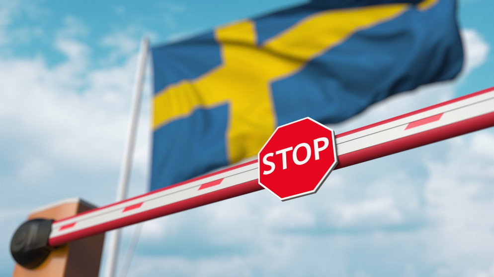 صورة توضيحية لعلامة منع دخول وخلفها علم السويد. (shutterstock)