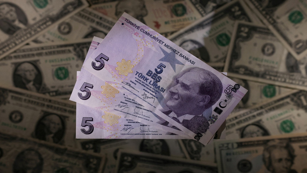 العملات الورقية بالليرة التركية موضوعة على الأوراق النقدية بالدولار الأميركي . 28 نوفمبر 2021. (رويترز)
