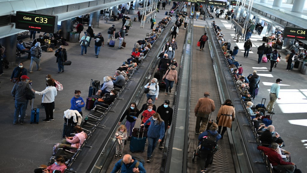 مسافرون يرتدون كمامات في مطار دنفر الدولي في دنفر بكولورادو في الولايات المتحدة، 30 تشرين الثاني/ نوفمبر 2021. (أ ف ب)