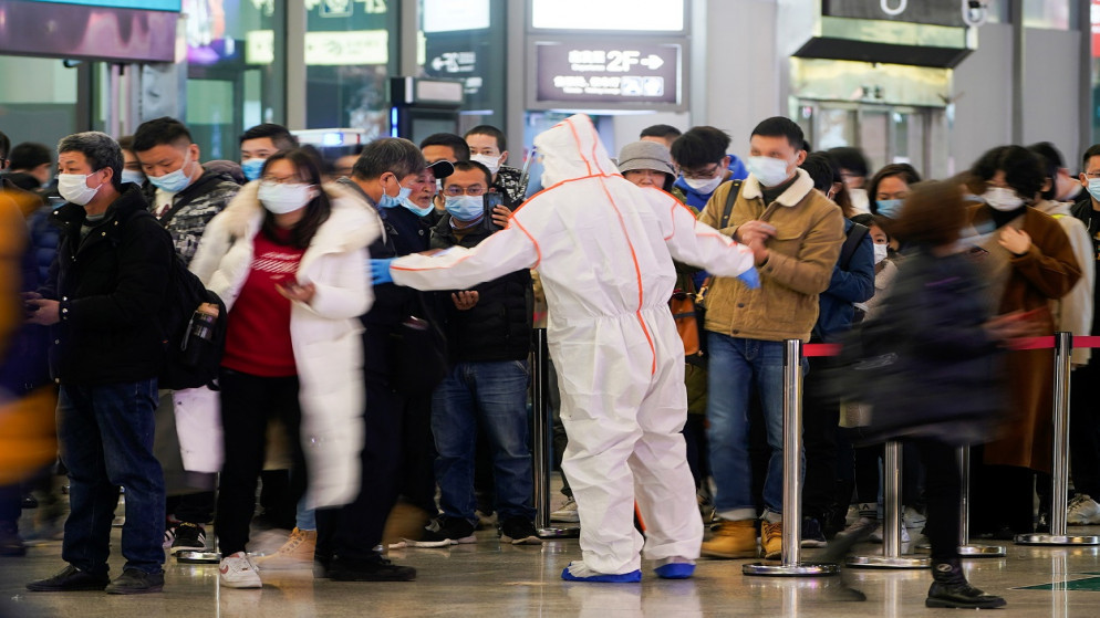 أحد حراس الأمن يوجّه الأشخاص لإجراء مسح فحص كورونا السريع لتتبع حالتهم الصحية في محطة سكة حديد شنغهاي في الصين. 25/11/2021. (رويترز)