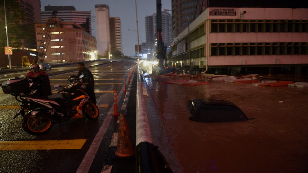 سيارة غارقة في مياه فيضانات الناجمة عن هطول أمطار غزيرة في كوالالمبور بماليزيا. 19/12/2021. (عارف كارتونو / أ ف ب)