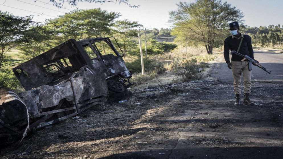 ضابط شرطة ينظر إلى شاحنة عسكرية مدمرة في كيميس ، إثيوبيا ، في 10 ديسمبر 2021. (أ ف ب)