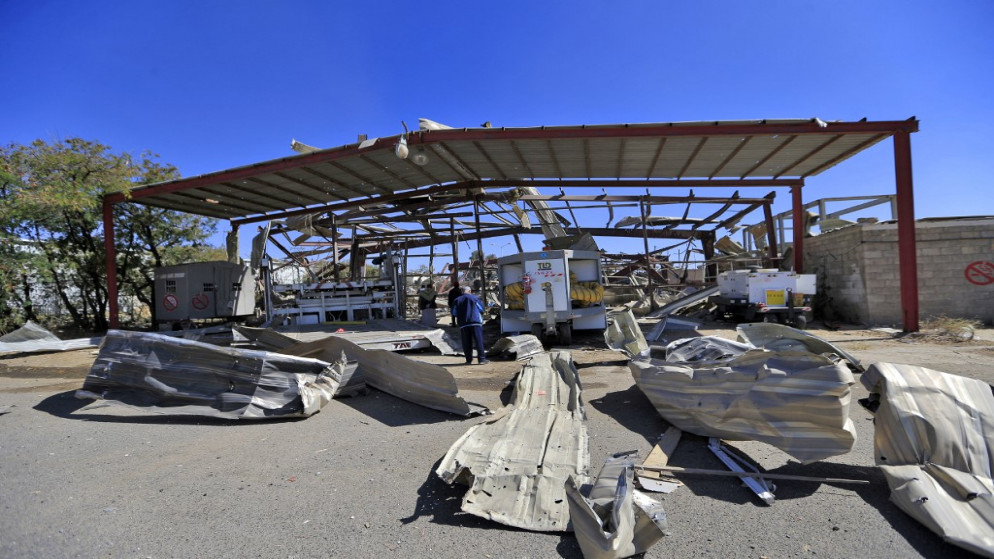 عمال المطار يقفون تحت الأنقاض في أعقاب غارة جوية شنتها قوات التحالف بقيادة السعودية استهدفت مطار صنعاء الدولي في العاصمة اليمنية في 21 كانون الأول/ ديسمبر 2021. (أ ف ب)