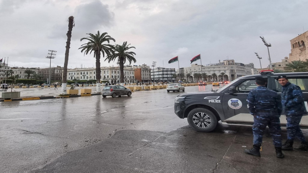 أفراد شرطة يقفون بجانب دورية ثابتة في ساحة الشهداء في العاصمة الليبية طرابلس، 13 ديسمبر 2021. (أ ف ب)
