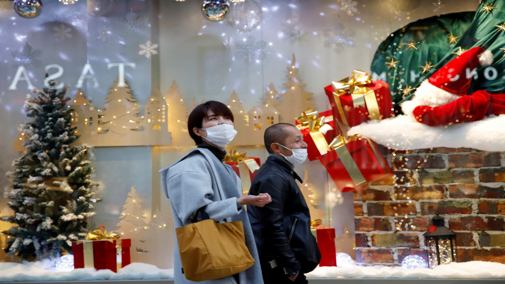 أشخاص يسيرون بزينة عيد الميلاد في اليوم الأول من إغلاق حدود اليابان لمنع انتشار فيروس أوميكرون في طوكيو. 30/11/2021. (أندرونيكي كريستودولو/ رويترز)