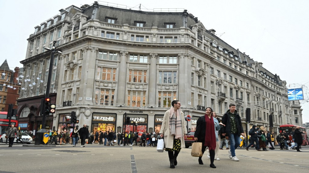 متسوقون، يرتدي بعضهم كمامات للوجه لمكافحة انتشار كورونا، يسيرون على طول شارع أكسفورد في لندن، 23 ديسمبر 2021. (أ ف ب)