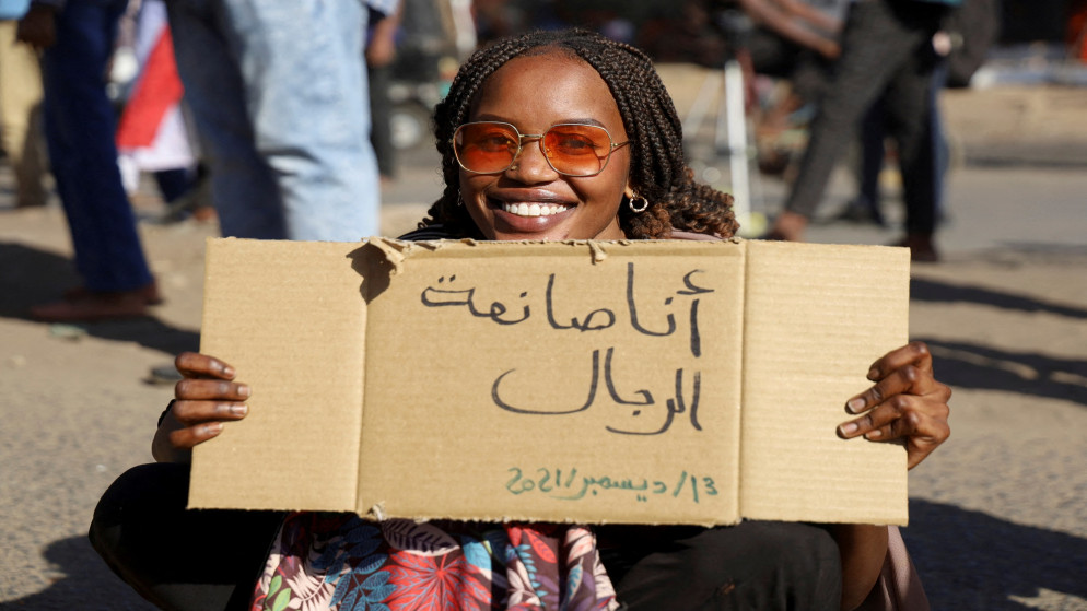 سيدة تحمل لافتة كتب عليها "أنا أصنع رجلاً" ، خلال تظاهرة تندد بالعنف ضد النساء في تظاهرة سابقة ضد الجيش السوداني في أم درمان. السودان. 23/12/2021. (الطيب صديق/ رويترز)