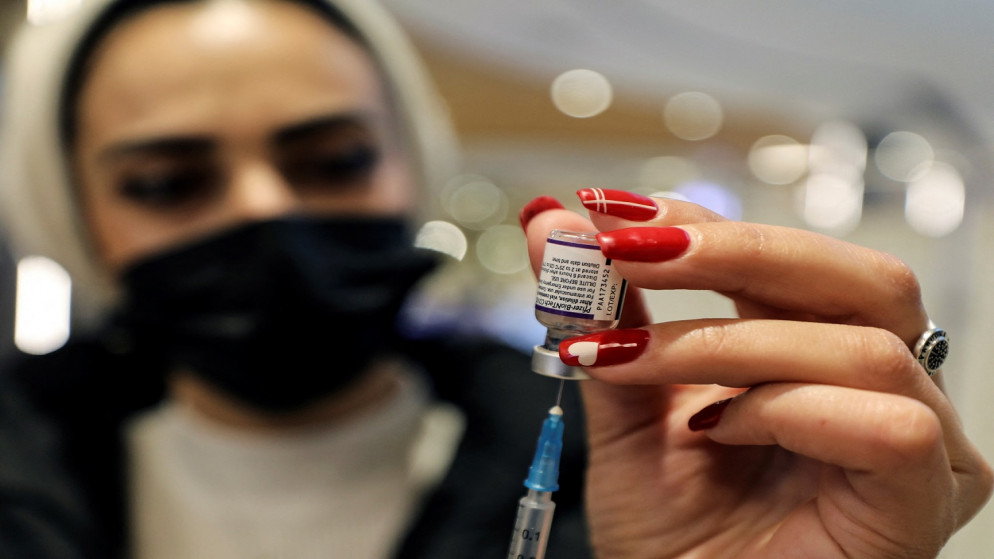 عامل صحي يعد جرعة من لقاح فيروس كورونا في القدس المحتلة، 22 ديسمبر 2021. (رويترز)