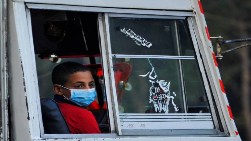 طالب يرتدي كمامة في حافلة في مصر وهو عائد إلى مدرسته بعد عودة التعليم الوجاهي في المدارس. (رويترز)