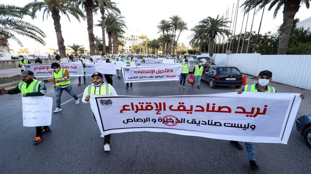 مجموعة من النشطاء الليبيين الشباب يحتجون على تأجيل الانتخابات الرئاسية في ساحة الشهداء بالعاصمة طرابلس . 25 ديسمبر 2021.(أ ف ب)