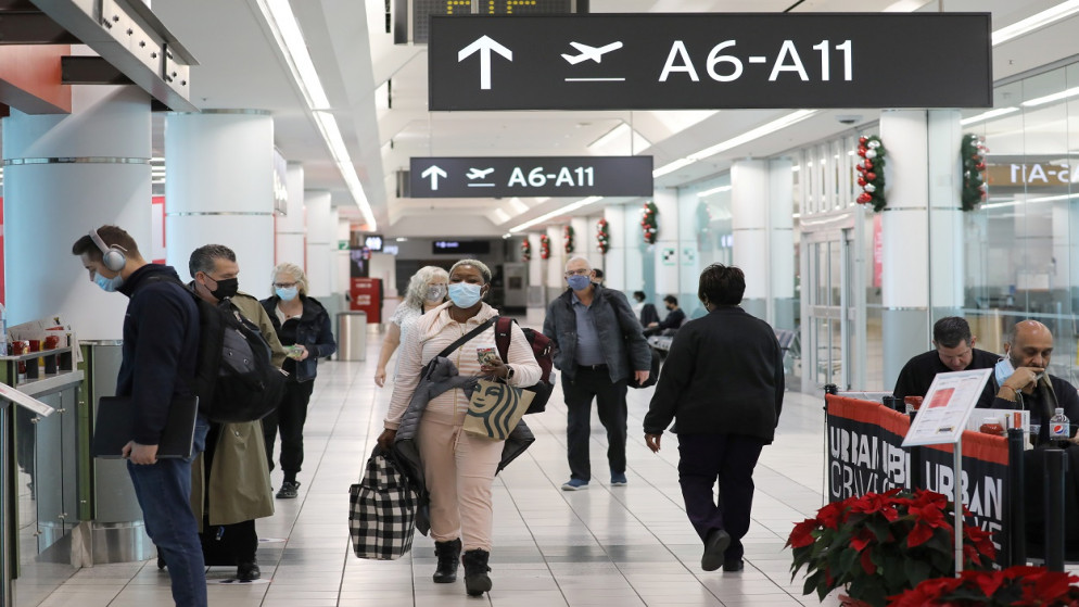 ركاب متجهون إلى الولايات المتحدة يسيرون في المبنى رقم 3 بمطار تورونتو بيرسون، 3 ديسمبر 2021. (رويترز)