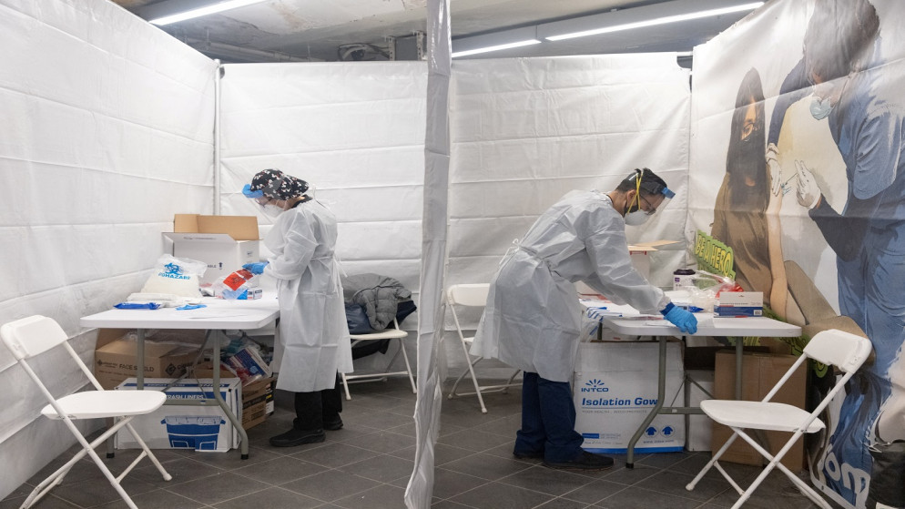 يعمل اثنان من العاملين في مجال الرعاية الصحية في موقع اختبار كورونا، في محطة مترو أنفاق تايمز سكوير، مدينة نيويورك، الولايات المتحدة، 27 كانون الأول/ديسمبر 2021. (أ ف ب)