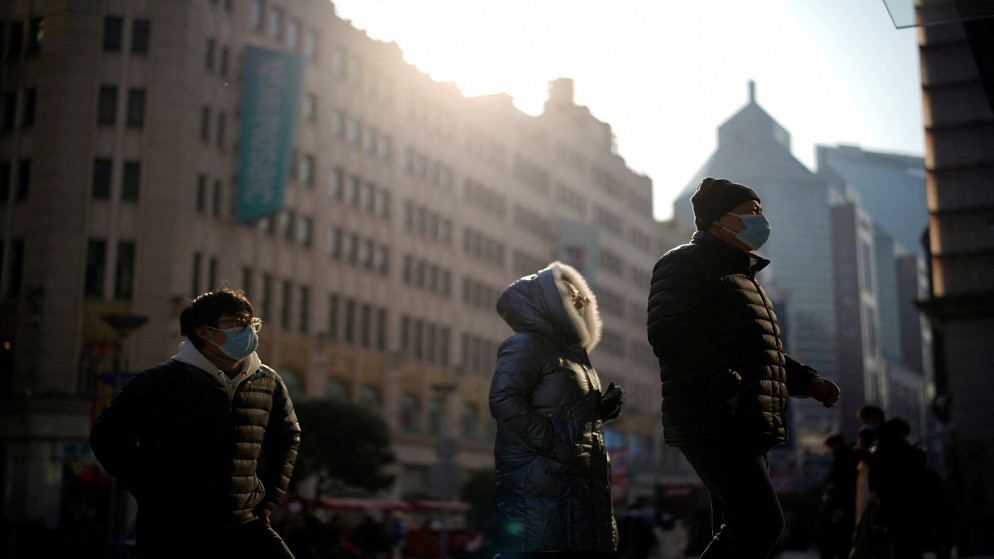 أشخاص يرتدون كمامات ويسيرون في شوارع، في شنغهاي، الصين، 30 كانون الأول/ديسمبر 2021. (رويترز)