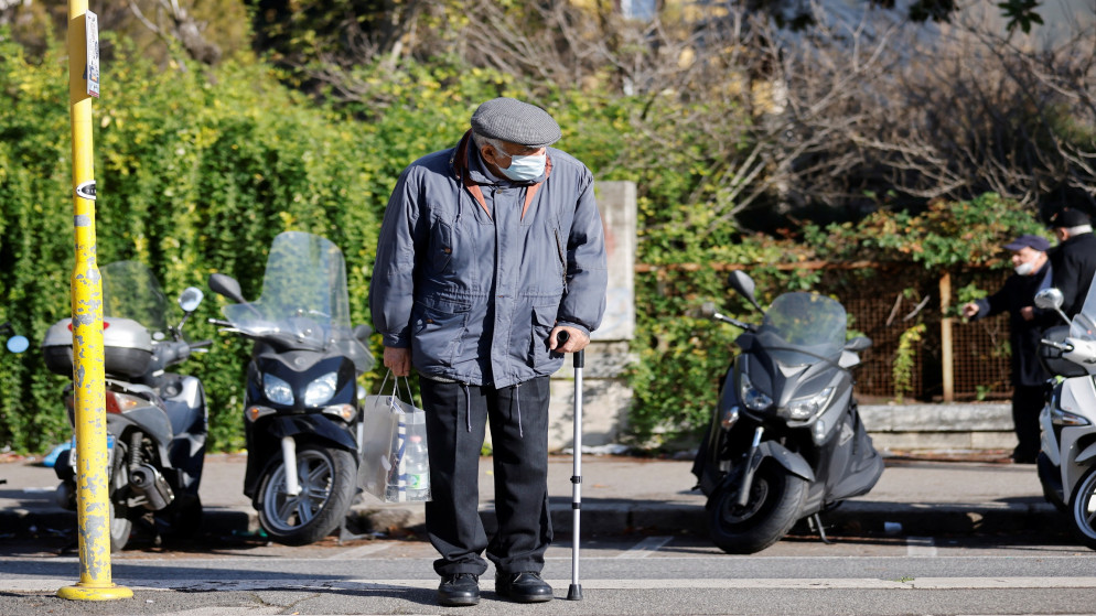 مسن يرتدي كمامة ويتكئ على عصاه في منطقة لاتسيو في روما، 23 كانون الأول/ديسمبر ، 2021. (رويترز)