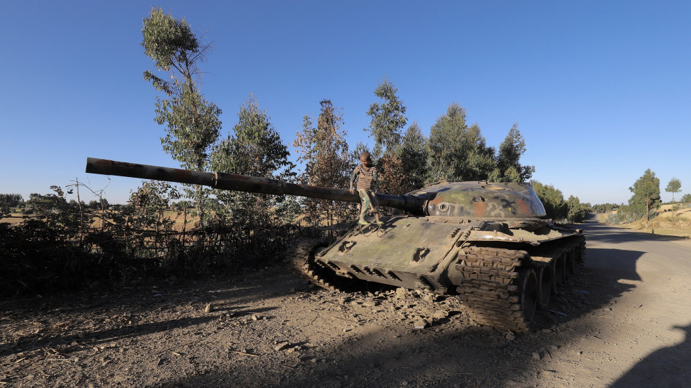 فتى يقف على دبابة مدمرة بعد معارك بين الجيش الإثيوبي وجبهة تحرير شعب تيغراي. (رويترز)