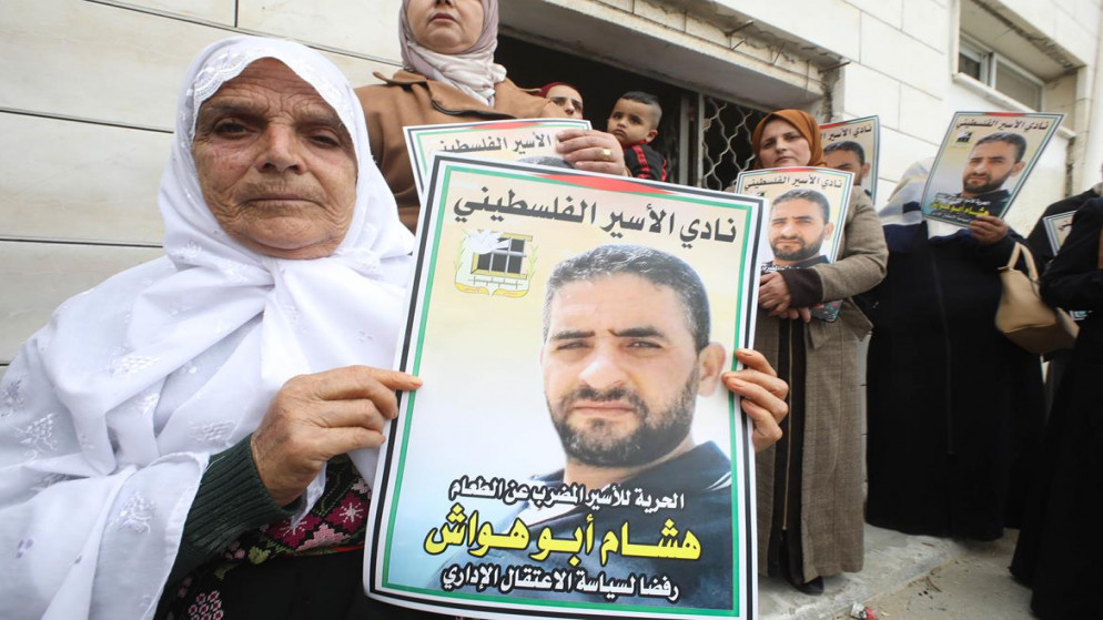 امرأة فلسطينية تحمل صورة الأسير هشام أبو هواش. (وفا)
