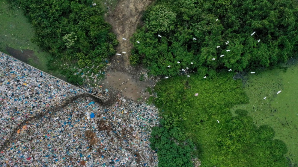 صورة جوية لسرب من الطيور يطير فوق نفايات بلاستيكية، مقاطعة آتشيه الإندونيسية. (أ ف ب)