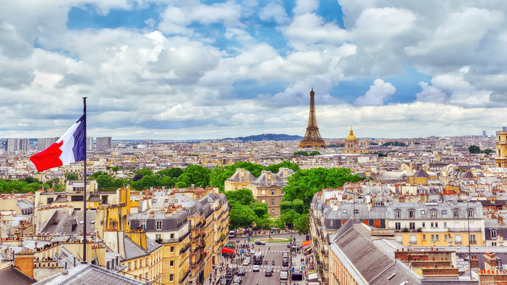 علم فرنسا ومن خلفه برج إيفل المعلم الشهير في العاصمة الفرنسية باريس. (shutterstock)