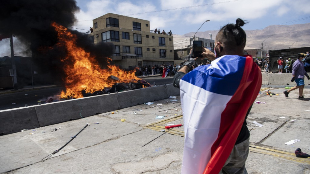 مخيم ميكيفت للمهاجرين الفنزويليين يحترق بعد أن أضرم المتظاهرون النار فيه خلال مسيرة احتجاجية ضد الهجرة غير الشرعية في إكيكي ، تشيلي .25 سبتمبر/أيلول 2021.(أ ف ب)