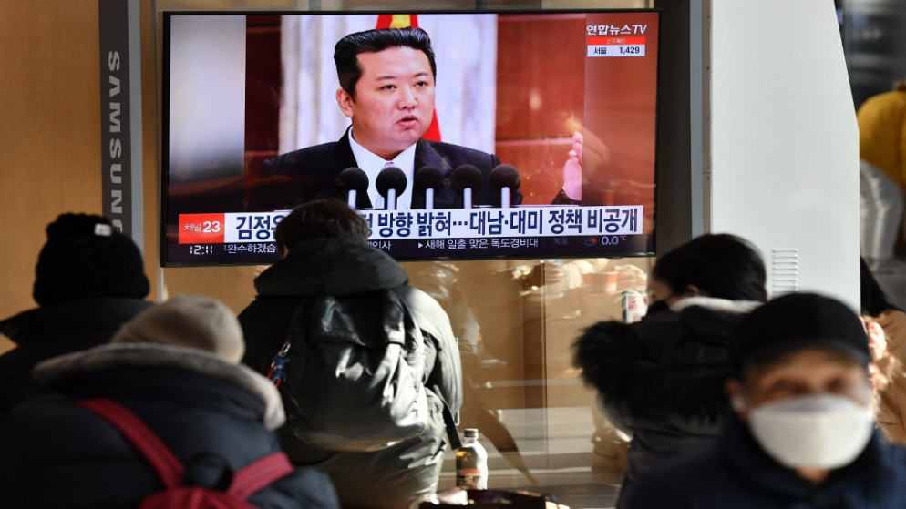 أشخاص يشاهدون برنامجا إخباريا تلفزيونيا يعرض صورة الزعيم الكوري الشمالي كيم جونغ-أون، في محطة سكة حديد في سول، 1 كانون الثاني/يناير 2022. (أ ف ب)