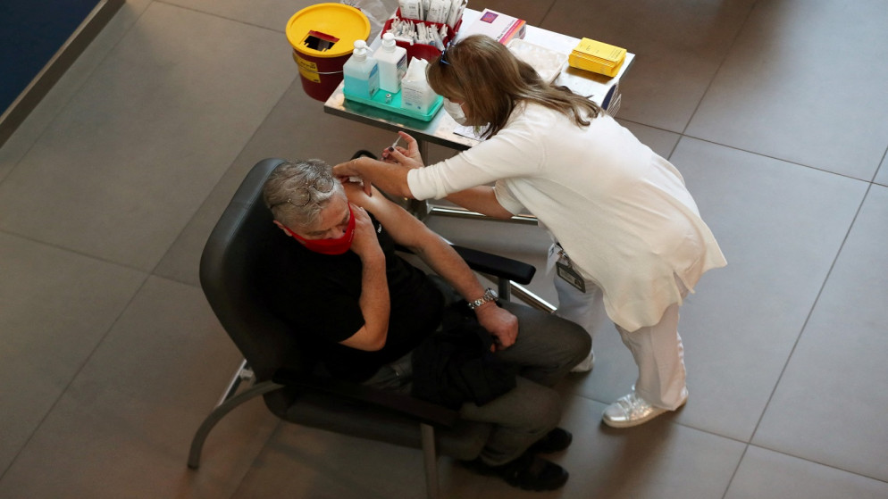 عاملة طبية تقوم بتلقيح رجل ضد فيروس كورونا، إسرائيل، 20 كانون الأول/ديسمبر 2020. (رويترز)