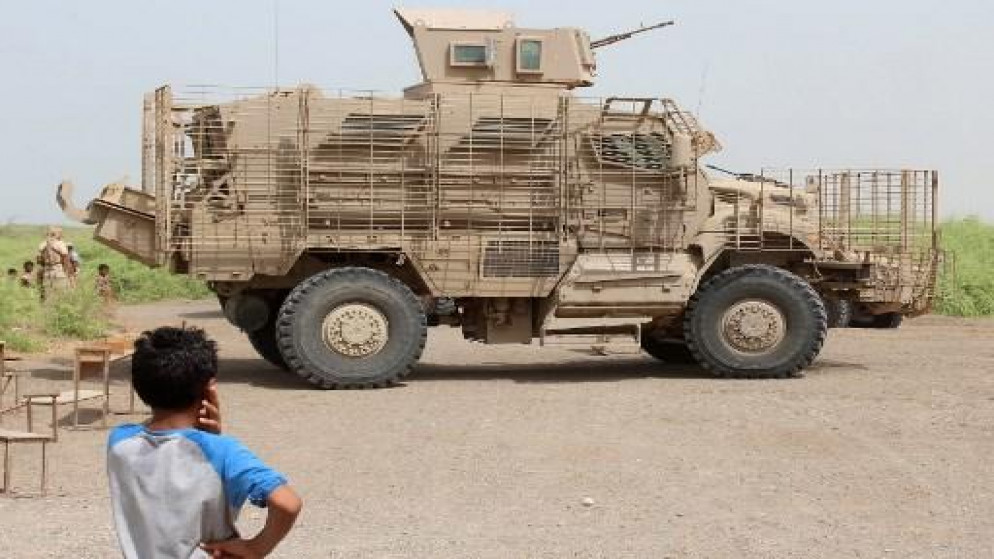 طفل يمني ينظر إلى مركبة مصفحة لقوات التحالف الذي تقوده السعودية ضد الحوثيين في اليمن، 22 يوليو 2018. (أ ف ب)