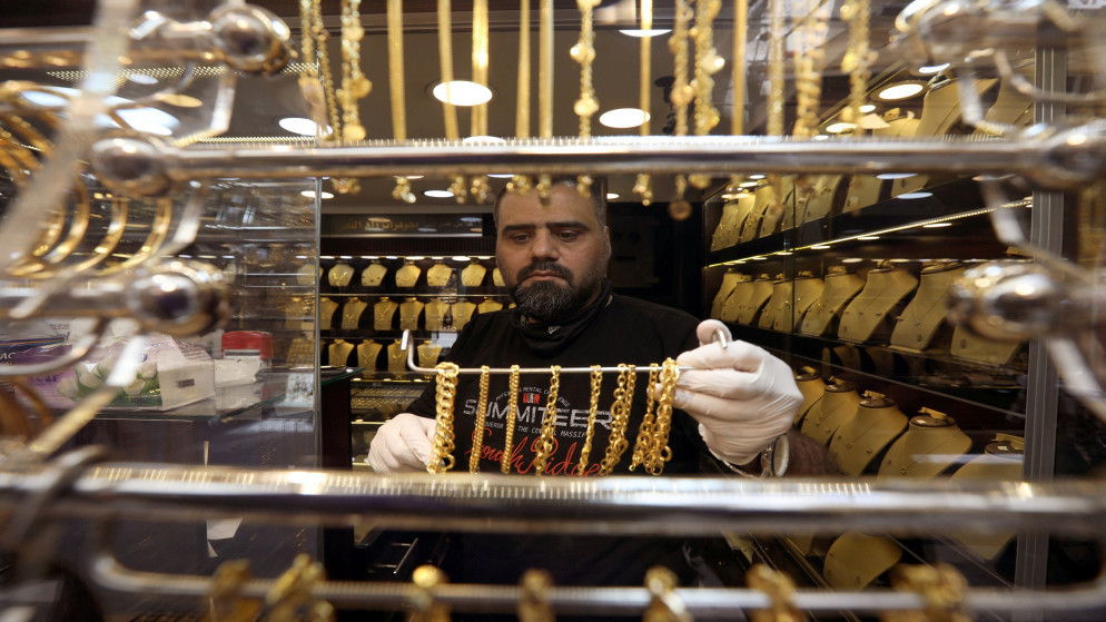 تاجر يعرض منتجاته من الذهب في سوق تجاري في عمّان. (رويترز)