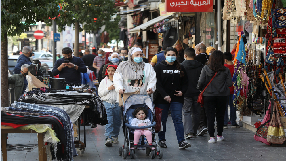 أشخاص يرتدون كمامات للوقاية من فيروس كورونا يسيرون في وسط مدينة عمّان وسط مخاوف من ارتفاع عدد حالات الإصابة بفيروس كورونا. (رويترز)