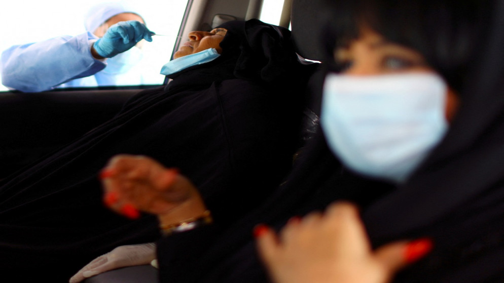 طاقم طبي، يأخذ مسحة من امرأة أثناء اختبار فيروس كورونا، بمركز فحص في أبو ظبي، الإمارات العربية المتحدة، 30 مارس 2020. (رويترز)
