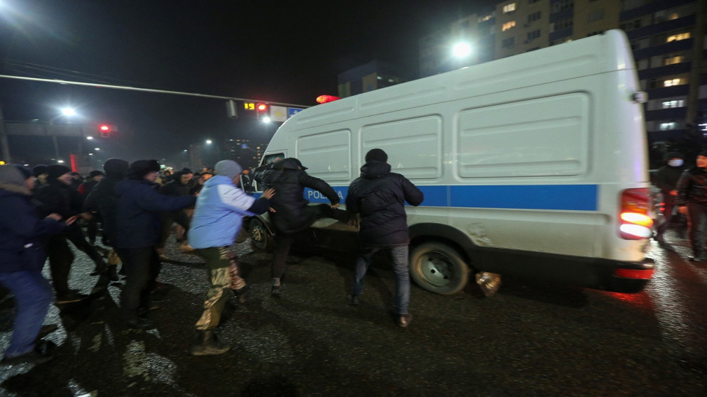أشخاص يهاجمون حافلة صغيرة تابعة للشرطة خلال احتجاج على ارتفاع تكلفة غاز البترول المسال، كازاخستان، 4 يناير 2022. (رويترز)