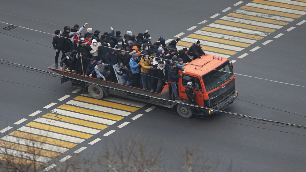 محتجون كازاخيون في مركبة في ألماتي في كازاخستان. (رويترز)