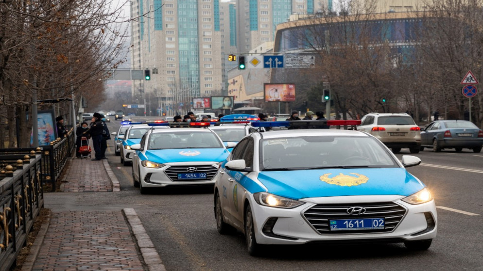 ضباط الشرطة وسياراتهم يغلقون شارعًا في وسط ألماتي، 7 يناير 2022. (أ ف ب)