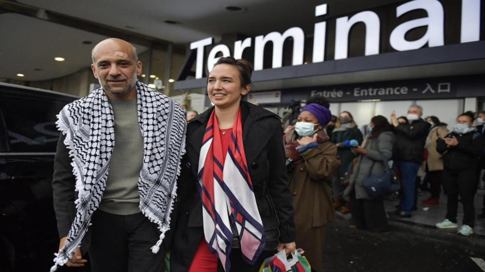 الناشط السياسي المصري-الفلسطيني وزوجته سيلين ليبرون شعث أثناء مغادرته مطار رويسي في فرنسا، 8 كانون الثاني/يناير 2022. (أ ف ب)
