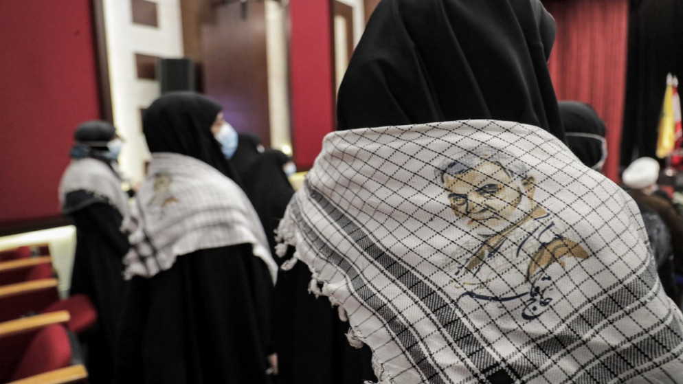امرأة ترتدي وشاحا رسم عليه صورة قائد فيلق القدس الذراع الخارجية للحرس الثوري الإيراني قاسم سليماني. (أ ف ب)