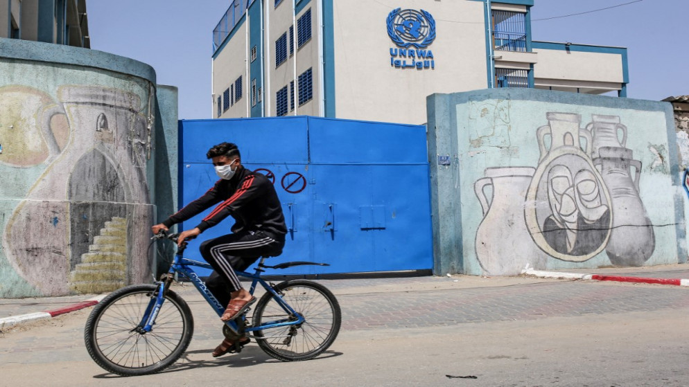 فلسطيني يركب دراجة هوائية أمام بوابة مغلقة لمدرسة تتبع وكالة "أونروا" في مدينة رفح جنوبي قطاع غزة، 6 نيسان/أبريل 2021. (سعيد خطيب/أ ف ب)