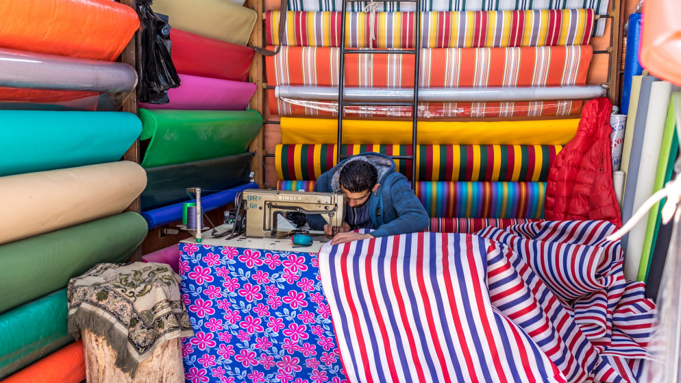 صورة توضيحية لشاب يعمل في مشغل خياطة في وسط البلد في عمّان. (shutterstock)