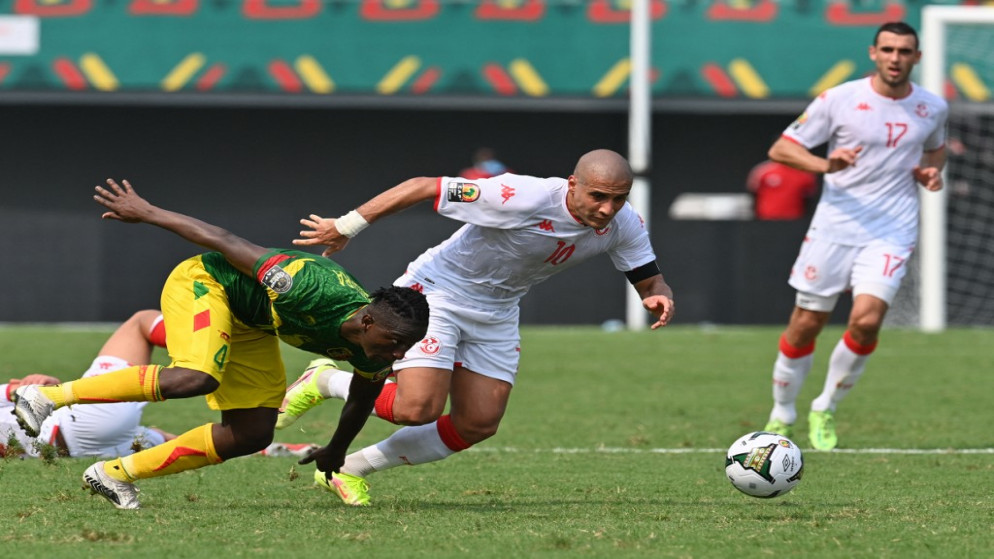 لاعب المنتخب التونسي وهبي الخزري يقاتل على الكرة مع لاعب منتخب مالي خلال مباراتهم في كأس الأمم الإفريقية. (أ ف ب)