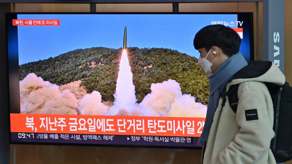 رجل يمشي أمام شاشة تلفزيونية، تُظهر تجربة صاروخ كوري شمالي، في محطة سكة حديد في سول، 17 كانون الثاني/يناير 2022. (أ ف ب)