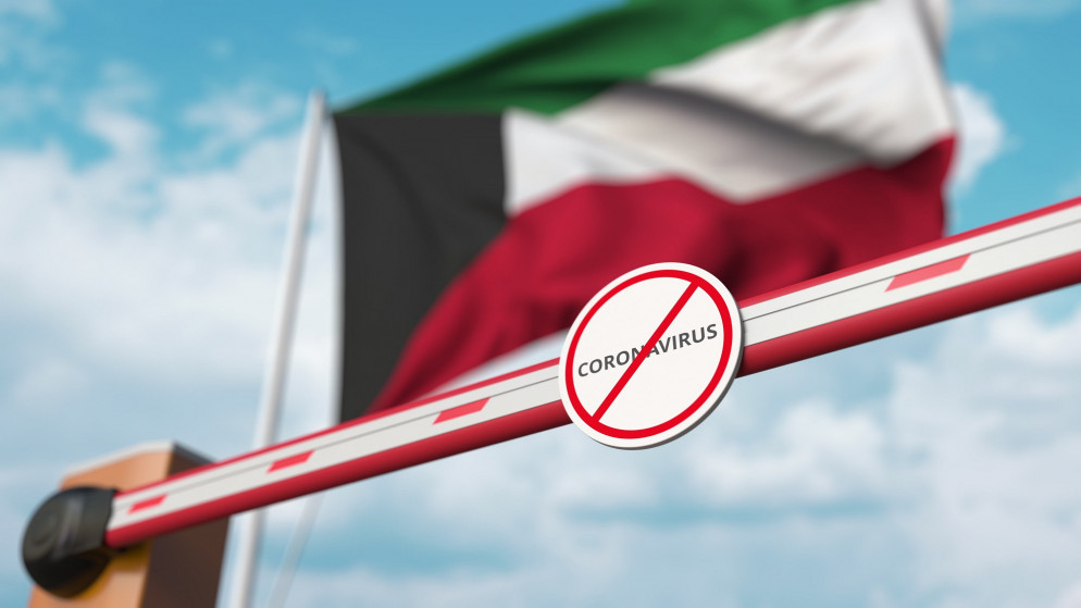 صورة توضيحية لحاجز وعليه إشارة منع وعبارة "فيروس كورونا" وخلفها علم الكويت. (shutterstock)