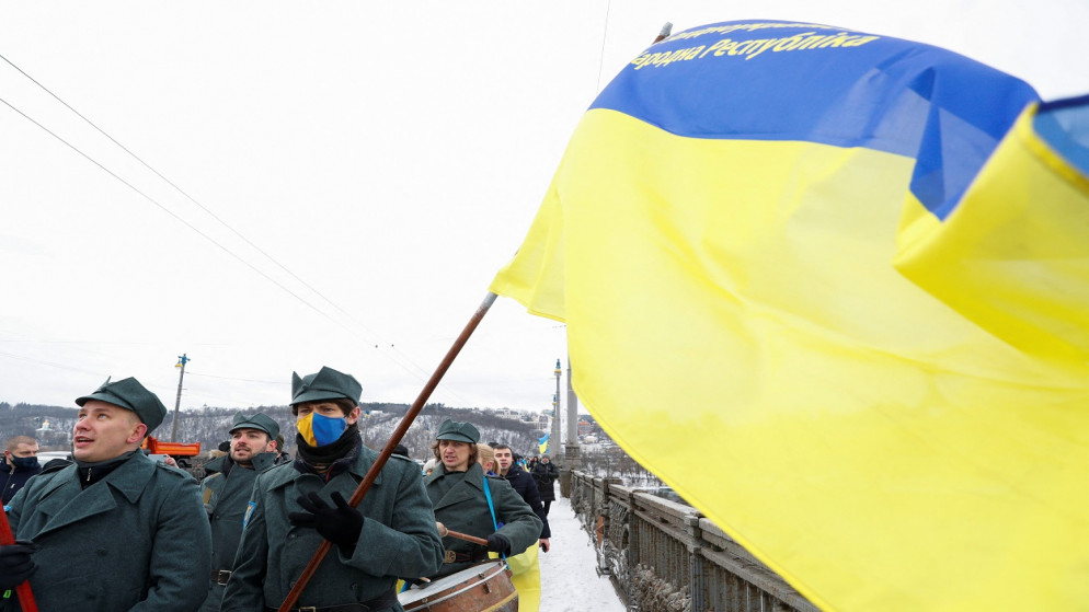 أشخاص يشاركون في موكب على طول جسر عبر نهر دنيبرو أثناء الاحتفال بيوم الوحدة في كييف، أوكرانيا، 22 يناير 2022. (رويترز)