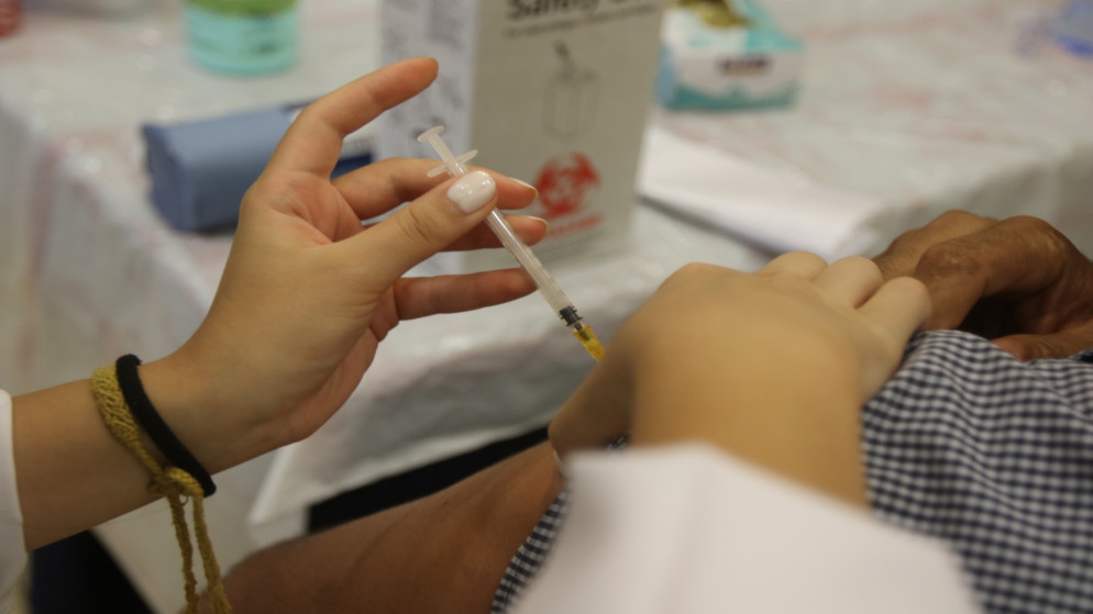 عاملة رعاية صحية تعطي لقاحا واقيا من فيروس كورونا في مركز تطعيم. (صلاح ملكاوي /المملكة)