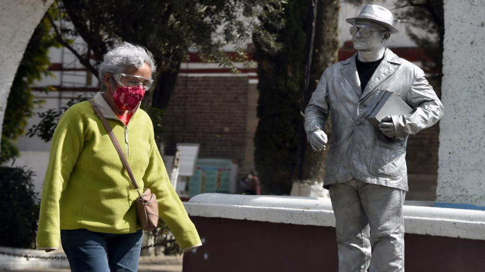 امرأة ترتدي قناعا واقيا من كورونا وتسير في شارع بالمكسيك. 24 كانون الثاني/يناير 2022.(أ ف ب)