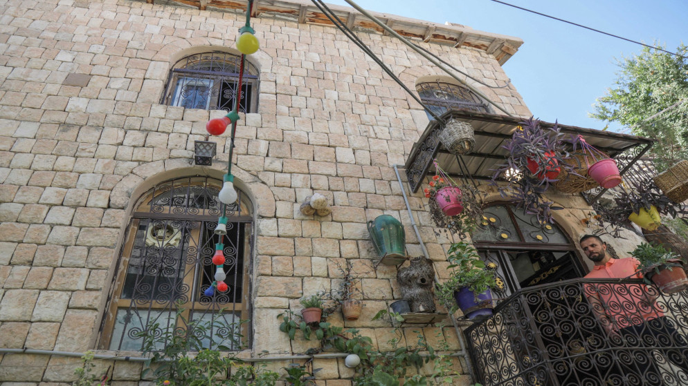 رجل يقف على شرفة منزل مبني بالحجارة في مدينة عقرة الكردية على بعد 500 كيلومتر شمال العاصمة العراقية بغداد. 14 أيلول/سبتمبر 2022. (أ ف ب)