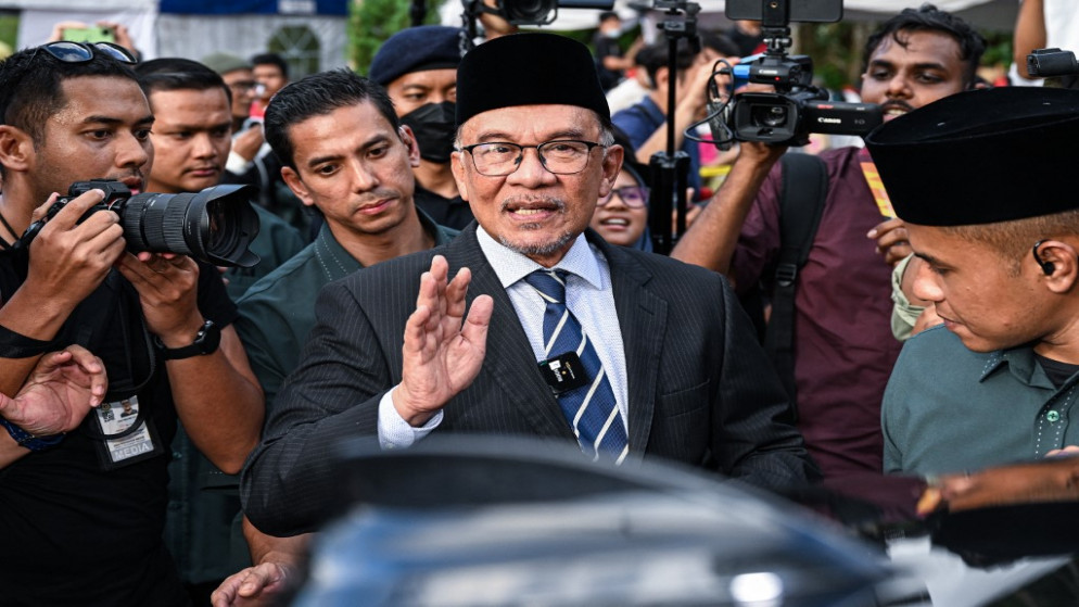 المعارض الإصلاحي أنور إبراهيم (في الوسط) وهو يغادر بعد اجتماعه مع ملك ماليزيا في القصر الوطني في كوالالمبور .22 تشرين الثاني/ نوفمبر 2022.(أ ف ب)