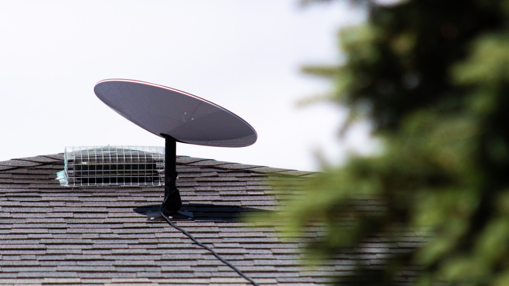 جهاز استقبال إنترنت عبر الأقمار الصناعية من سبيس إكس ستارلينك مثبتًا على سطح منزل في مجتمع ريفي كندي.(shutterstock)