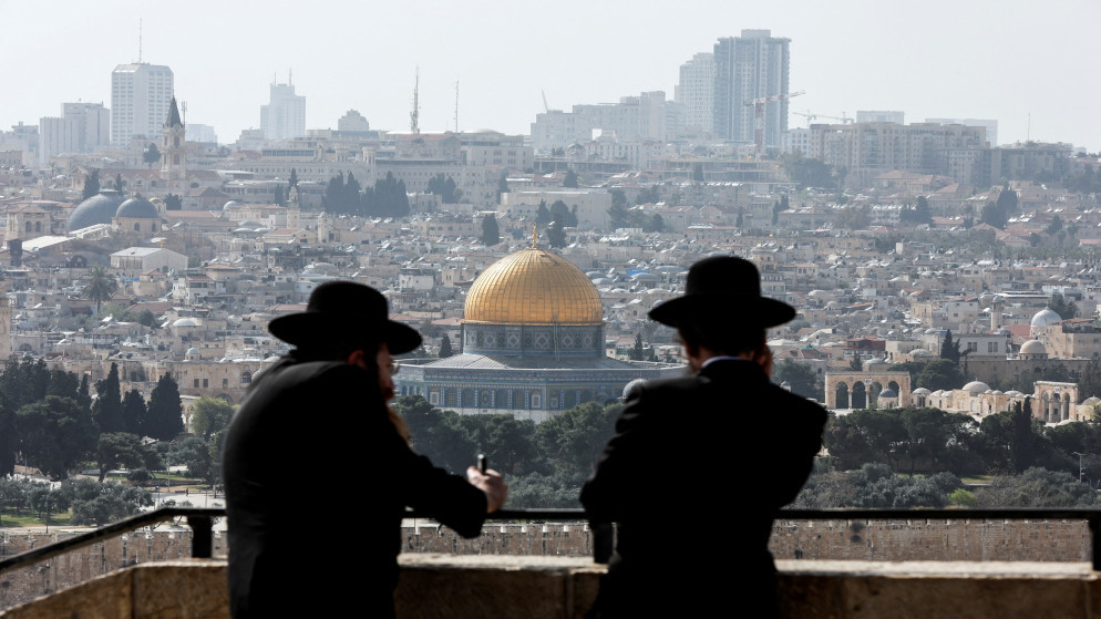 يهوديان متشددان يقفان عند نقطة من جبل الزيتون وينظرون إلى البلدة القديمة في القدس المحتلة، 10 نيسان/أبريل 2022. (رويترز)